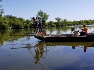 Image of people in a boat performing a fish survey on Normandale Lake