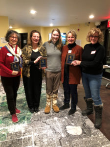 volunteers holding award plaques