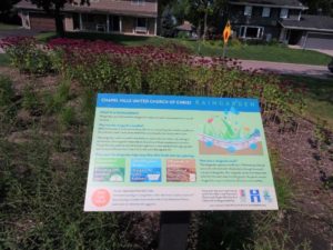 Image of an informational sign in front of blooming flowers