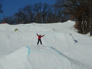 Child going off a jump while downhill skiing.