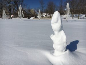 A sculpture made out of snow, resembles a snowman