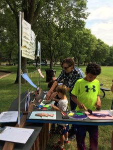 People painting fish prints at a park