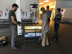 Staff use the watershed sandbox exhibit