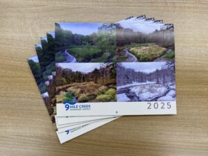 A stack of 2025 calendars on a table.