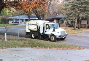 Street sweeper collecting leaves on a residential street