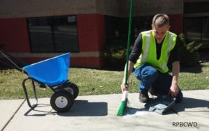 image of worker sweeping up fertilizer